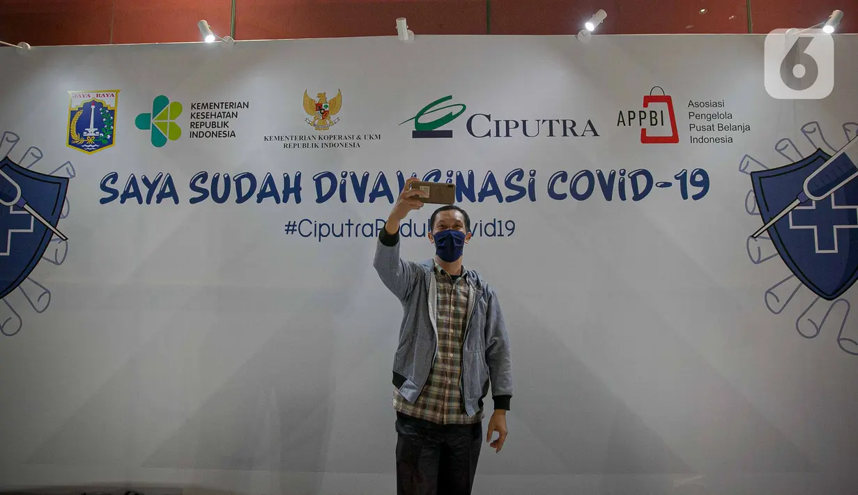 Seorang pelaku UMKM berselfie usai melakukan vaksin COVID-19 kepada pelaku UMKM di Jakarta, Kamis (1/4/2021). Vaksin diberikan kepada 1.500 pelaku UMKM dan target kanvaksinasi bagi pelaku UMKM di DKI Jakarta mencapai 250.000. (Liputan6.com/Faizal Fanani)