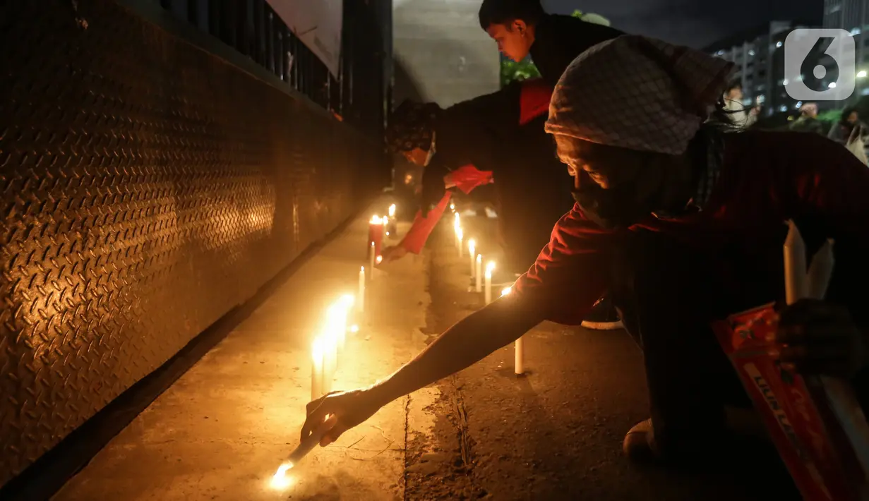 Aksi massa membawa lilin dan doa bersama lintas agama di depan Gedung DPR, Jakarta, Kamis (16/3/2023). Dalam aksinya, mereka menuntut agar pimpinan DPR menetapkan RUU PPRT sebagai RUU INISIATIF DPR di Rapat Paripurna pada Selasa, 21 Maret 2023 mendatang. (Liputan6.com/Johan Tallo)