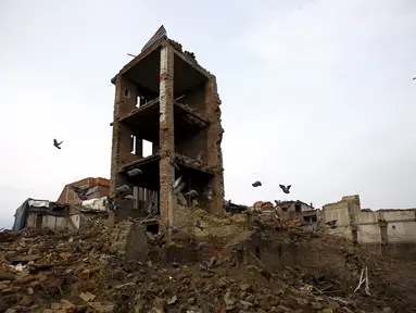 Burung merpati berterbangan di dekat bangunan yang rusak akibat gempa di Bhaktapur, Nepal (14/7/2015). PBB melaporkan dua bulan setelah gempa di Nepal, warga masih sulit mendapatkan makanan dan perawatan kesehatan. (REUTERS/Navesh Chitrakar)