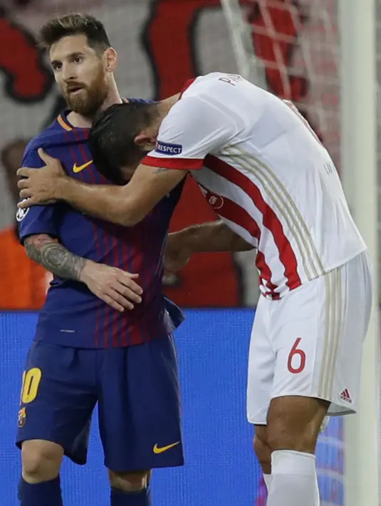 Pemain Olympiakos, Panagiotis Tachtsidis memberi penghormatan kepada pemain Barcelona, Lionel Messi usai laga babak penyisihan Grup D Liga Champions di Georgios Karaiskáki, Rabu (1/11). Blaugrana harus puas dengan hasil seri 0-0. (AP/Thanassis Stavrakis)