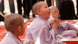 Seorang anak lelaki bernama Budha Bon Young menguap setelah kepalanya dicukur saat kebaktian merayakan ulang tahun ke-2.563 Buddha di Kuil Jogye di Seoul, Korea Selatan, Senin (22/4). Perayaan ulang tahun Buddha akan jatuh pada 12 Mei mendatang. (AP Photo/Ahn Young-joon)