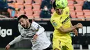 Bek Valencia, Jose Gaya (kiri) berebut bola dengan penyerang Villarreal, Gerard Moreno pada pertandingan lanjutan La Liga Spanyol di stadion Mestalla di Valencia (6/3/2021). Valencia sempat tertinggal lebih dulu lewat gol penalti Gerard Moreno pada menit ke-40. (AFP/Jose Jordan)