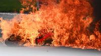 Kecelakaan parah menimpa Dani Pedrosa dan Lorenzo Savadori hingga motor keduanya terbakar dilahap api. (JOE KLAMAR / AFP)