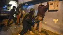Anggota polisi menggeledah orang-orang saat operasi di tengah pandemi COVID-19 di Los Teques, negara bagian Miranda, Venezuela, 20 Maret 2021. Di Miranda ada pembatasan keluar sejak pukul 18.00 dan perintah penutupan toko pada pukul 16.00 di tengah gelombang kedua pandemi. (Federico PARRA/AFP)