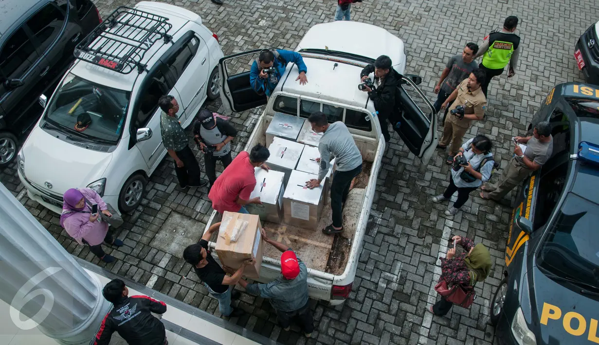 Petugas membawa kotak suara yang akan didistribusikan ke kelurahan di Kecamatan Menteng, Jakarta, Senin (17/4). Logistik surat suara ini siap digunakan untuk Pilkada DKI Jakarta putaran kedua 19 April 2017. (Liputan6.com/Gempur M Surya)
