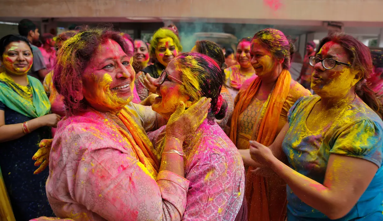 Sejumlah wanita bermain dengan bubuk berwarna saat mengikuti Festival Holi di Prayagraj, India, Selasa (10/3/2020). Festival Holi menandai datangnya musim semi di India. (AP Photo/Rajesh Kumar Singh)