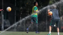 Semprotan air melintasi dekat asisten pelatih Miguel Gandia (kanan) saat memberikan instruksi pada sesi latihan Timnas U-22 Indonesia di Lapangan SPH, Karawaci, Jumat (17/3/2017).  (Bola.com/Nicklas Hanoatubun)