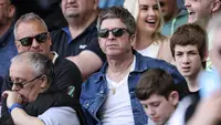Mantan personil band Oasis, Noel Gallagher, menyaksikan langsung pertandingan antara Manchester City vs Fulham pada laga pekan ke-37 Premier League di Craven Cottage, Sabtu (11/5/2024). City menang empat gol tanpa balas. (AFP/Adrian Dennis)