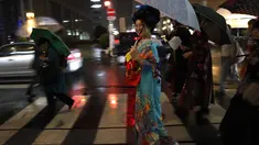 Seorang wanita Jepang tersenyum mengenakan pakaian tradisional saat berjalan di jalan setelah menghadiri peragaan busana kimono di Oita (18/10/2019). Pada zaman sekarang, kimono berbentuk seperti huruf "T", mirip mantel berlengan panjang dan berkerah. (AP Photo/Christophe Ena)