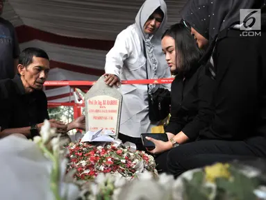 Warga membaca doa di depan makam Presiden ketiga RI BJ Habibie di TMP Kalibata, Jakarta, Kamis (12/9/2019). Tidak hanya dihadiri tokoh-tokoh penting, ratusan warga juga antusias datang ke TMP Kalibata untuk mengantarkan BJ Habibie ke tempat peristirahatan terakhirnya. (merdeka.com/Iqbal Nugroho)