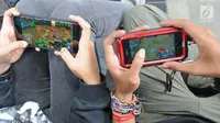 seorang pemuda lagi asik main games di gadget di Jakarta, Senin (29/01/2018). Organisasi kesehatan dunia (WHO) bakal menetapkan kecanduan bermain game sebagai salah satu gangguan mental. (Liputan6.com/Herman Zakharia)