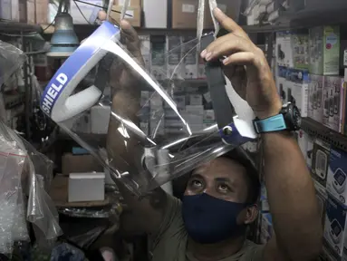Pedagang merapikan alat pelindung wajah atau face shield di salah satu kios Pasar Pramuka, Jakarta, Rabu (3/6/2020). Jelang pemberlakuan new normal, penjualan face shield meningkat dalam beberapa hari terakhir. (merdeka.com/Iqbal S. Nugroho)