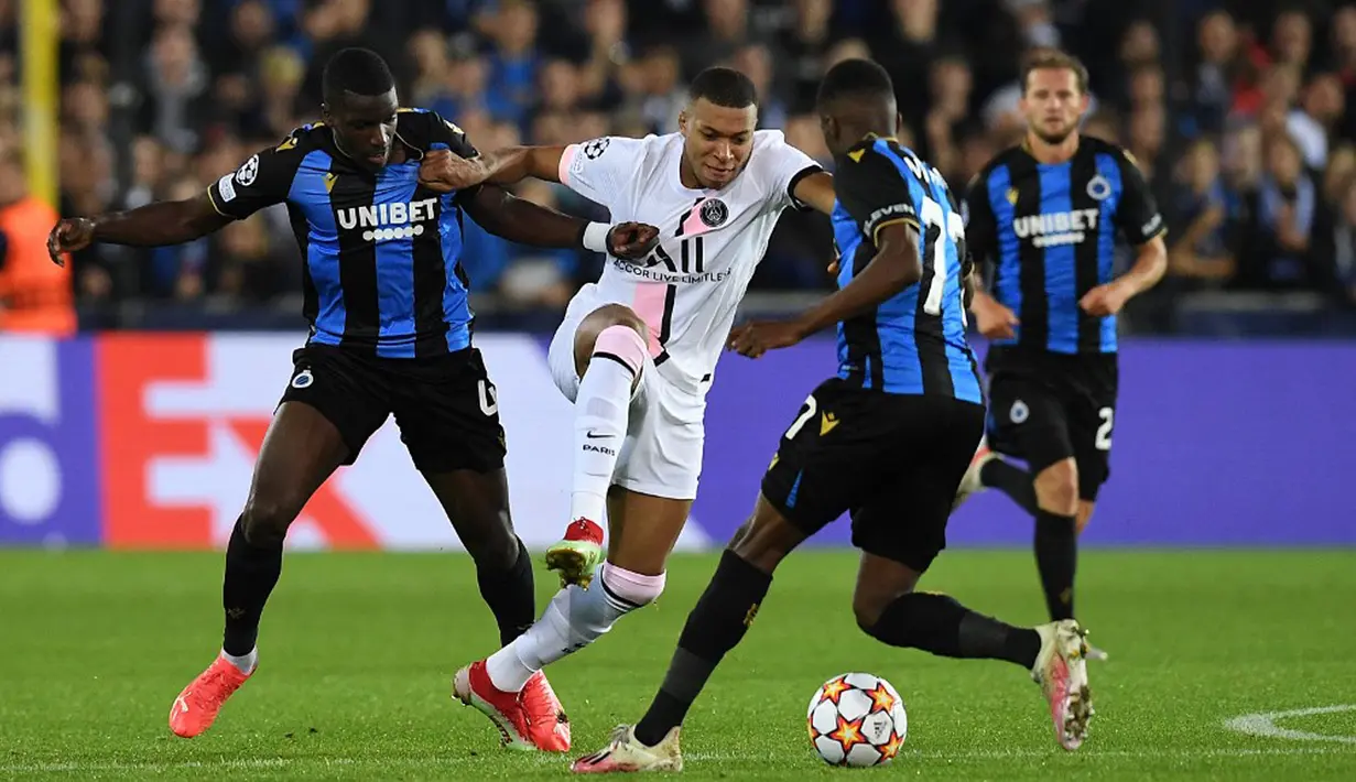 Pemain Paris Saint-Germain Kylian Mbappe (tengah) berebut bola dengan pemain Club Brugge Stanley Nsoki (kiri) dan Clinton Mata pada pertandingan Grup A Liga Champions di Stadion Jan Breydel, Bruges, Belgia, Rabu (15/9/2021). Pertandingan berakhir imbang 1-1. (JOHN THYS/AFP)