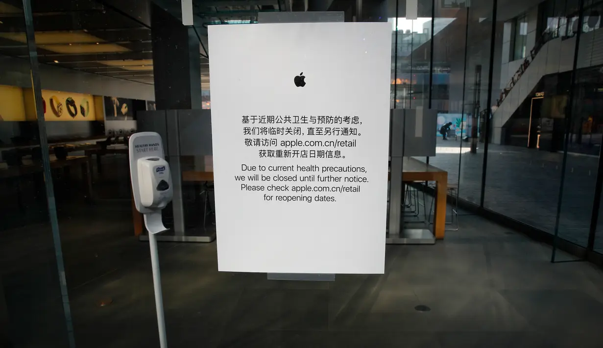 Apple Store memajang pemeritahuan penutupan tokonya di Beijing, China, Senin (10/2/2020). Apple Store di China dibuka kembali dalam waktu terbatas, pukul 11.00 hingga 18.00. (AP Photo/Andy Wong)