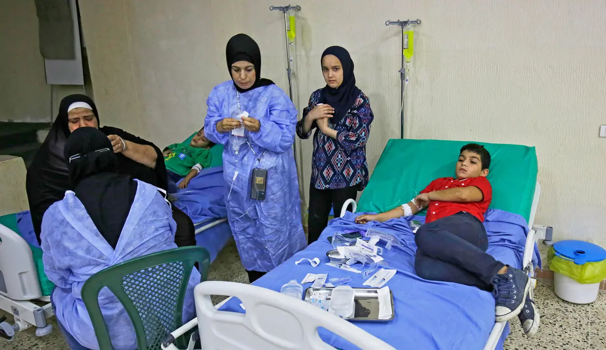 Pasien yang terinfeksi wabah kolera Vibrio menerima perawatan di aula masjid yang diubah menjadi rumah sakit lapangan di Kota Bebnine, Distrik Akkar, Lebanon Utara, Rabu (26/10/2022). Ini adalah wabah kolera pertama di Libanon sejak kasus terakhir dilaporkan pada tahun 1993 tanpa ada penularan lokal. (AFP/Ibrahim Chalhoub)