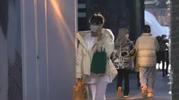 Seorang wanita memakai masker saat mengunjungi pusat perbelanjaan di Beijing, China, Selasa (14/12/2021). Kasus pertama varian omicron COVID-19 telah terdeteksi di daratan negara di kota Tianjin di sebelah timur Beijing. (AP Photo/Ng Han Guan)