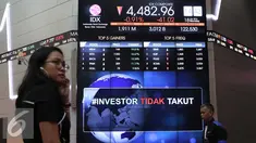 Pengunjung melintas di bawah layar bertuliskan #investor tidak takut di Bursa Efek Indonesia, Jakarta, Senin (18/1). Direktur utama BEI Tito menjelaskan tidak terjadi pengaruh besar pasca teror terhadap perdagangan di BEI. (Liputan6.com/Angga Yuniar)