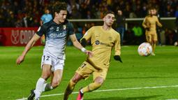 Pemain Ceuta, Juan Gutierrez, berebut bola dengan pemain Barcelona, Ferran Torres, pada laga Copa del Rey di Stadion Alfonso Murube (19/1/2023). Bertanding di Stadion Alfonso Murube pada Jumat (20/1/2023), Barcelona sukses menumbangkan Ceuta dengan skor 5-0. (AP Photo/Antonio Sempere)
