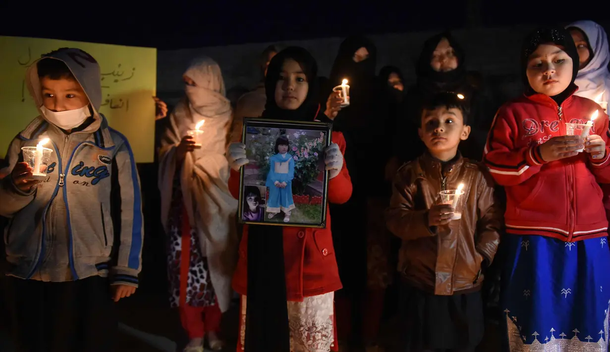 Sejumlah anak membawa lilin dan foto Zainab Ansari, gadis 8 tahun yang diculik, diperkosa dan dibunuh di kota Kasur di provinsi Punjab, di Quetta, Pakistan (11/1). Ratusan pemrotes marah kepada polisi akibat kematian Zainab. (AFP Photo/Banaras Khan)