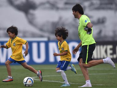 Pemain Brasil, Kaka berlatih didampingi putranya yang bernama Luca saat persiapan jelang laga penyisihan Piala Dunia 2018 melawan Argentina di Sao Paulo, Brasil, Selasa (10/11/2015). (AFP Photo/Nelson Almeida) 
