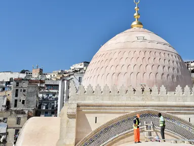 Pekerja sedang membersihkan bagian atap dekat kubah Masjid Ketchaoua atau Katsyawah di distrik Casbah, Aljir, Aljazair, Rabu (15/11). Masjid ini dibangun pada masa Dinasti Ottoman di abad ke-17. (AFP Photo/Ryad Kramdi)