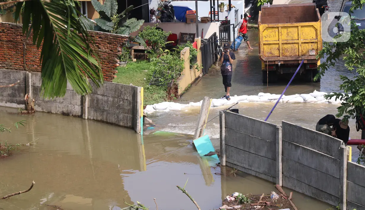 Kondisi banjir di Perumahan Nerada Estate Ciputat akibat jebolnya tanggul karena tertimpa tanah longsor, di Tangerang Selatan, Banten, Sabtu (12/6/2021). Longsor yang menimpa sejumlah rumah membuat tanggul pembatas kali jebol dan air meluap sehingga menyebabkan banjir. (Liputan6.com/Angga Yuniar)