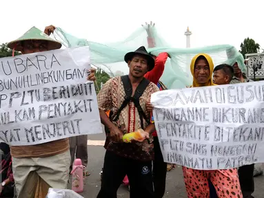 Beberapa warga melakukan unjuk rasa di depan Istana Negara, Jakarta, Senin (17/1). Dalam aksinya, mereka menolak pembangunan mega proyek Pembangkit Listrik Tenaga Uap (PLTU) di Cirebon. (Liputan6.com/Helmi Fithriansyah)