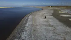 Sepasang suami istri berjalan di sepanjang tepi air yang surut setelah level air terendah terlihat di Great Salt Lake (6/9/2022). Gelombang panas terik memecahkan rekor di Utah, di mana suhu mencapai 105 derajat Fahrenheit (40,5 derajat Celcius) pada hari Selasa, menjadikannya hari terpanas September yang tercatat sejak tahun 1874. (AP Photo/Rick Bowmer)