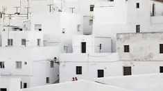 Pasangan berjalan di antara bangunan serba putih di Pueblos Blancos, Andalusia, Spanyol, 16 September 2016. Pueblos Blancos atau Desa Putih merupakan kota yang terdiri dari sekumpulan desa dengan seluruh bangunan bercat putih. (REUTERS/Marcelo del Pozo)