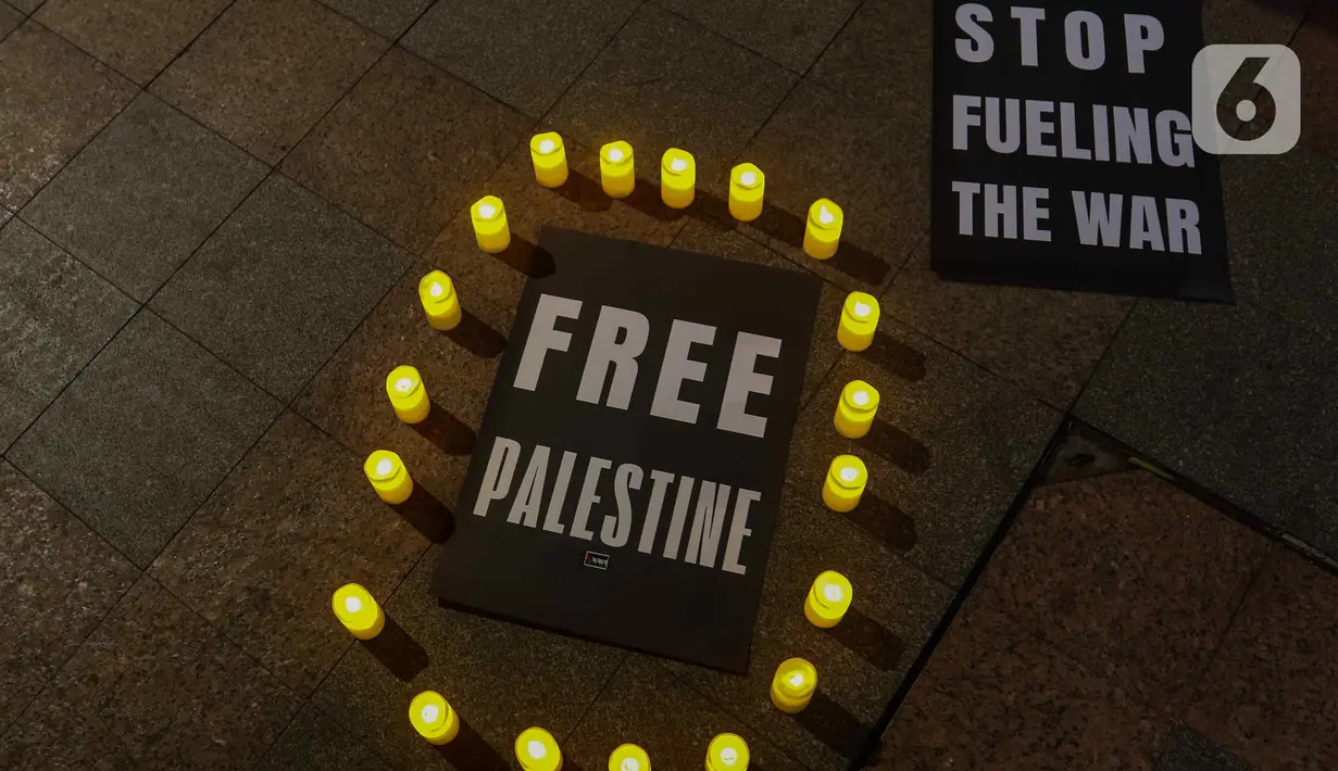 Aktivis Greenpeace Indonesia menyalakan lilin saat menggelar aksi solidaritas untuk Palestina di kawasan Bundaran HI, Jakarta, Jumat (3/11/2023). (Liputan6.com/Herman Zakharia)