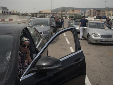 Penumpang dengan mobil mereka antre untuk menaiki feri menuju Tangier di pelabuhan Algeciras, Spanyol, Rabu (15/6/2022). Ribuan warga negara Maroko yang bekerja dan tinggal di Eropa melewati Selat Gibraltar saat mereka kembali untuk menghabiskan liburan musim panas di Maroko. (JORGE GUERRERO / AFP)