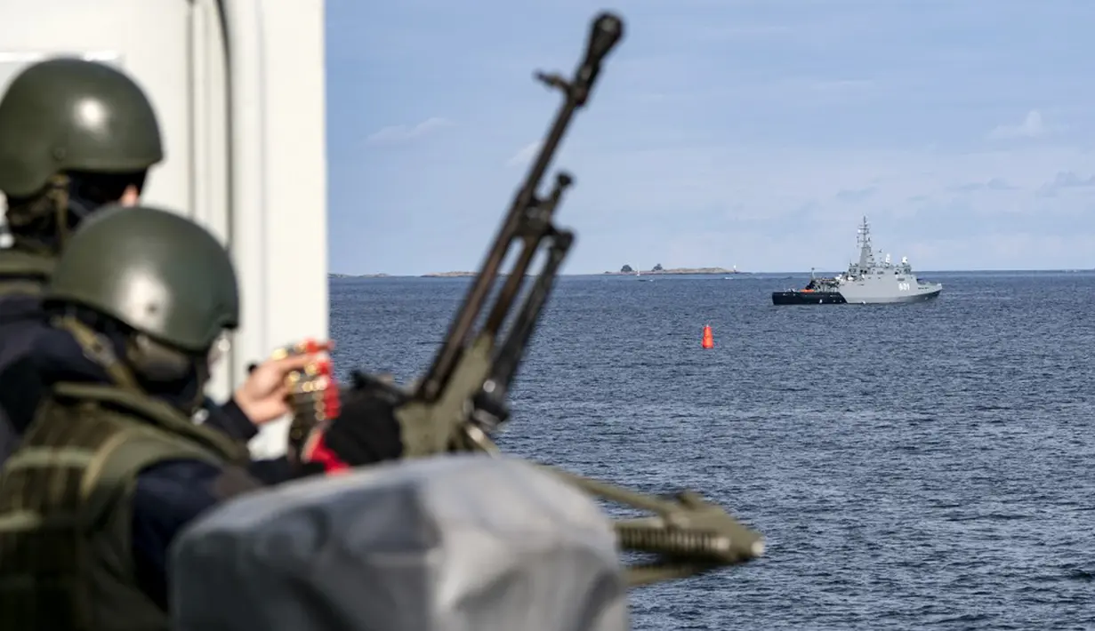 Penembak senapan mesin di kapal HMS Trosso (A264) (kiri) digambarkan dan kapal penyapu ranjau Polandia Kormoran (belakang) saat latihan ranjau di luar Vastervik, Swedia, 21 September 2021. Northern Coasts diadakan di Laut Baltik sejak 2007. (JOHAN NILSSON/TT NEWS AGENCY/AFP)