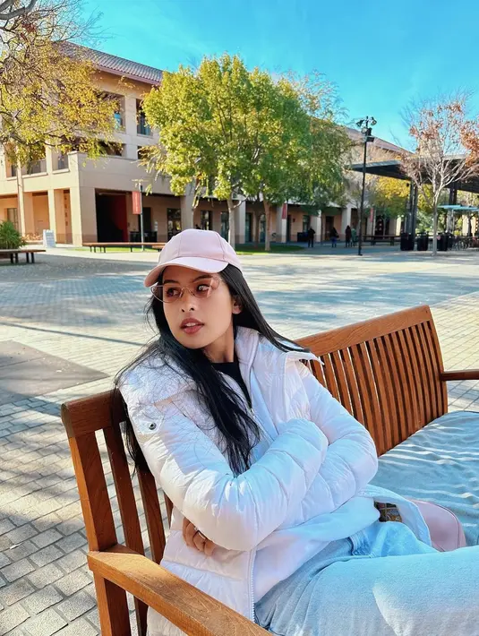 Dalam mood warna putih dan pink, Maudy tampil berlapis namun tetap chic dengan vest puffer dan topi warna baby pink. [@maudyayunda]