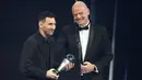 Presiden FIFA, Gianni Infantino, memberikan trofi penghargaan kepada Lionel Messi sebagai pemain terbaik FIFA 2022 di Paris, Selasa (28/2/2023). (AP Photo/Michel Euler)