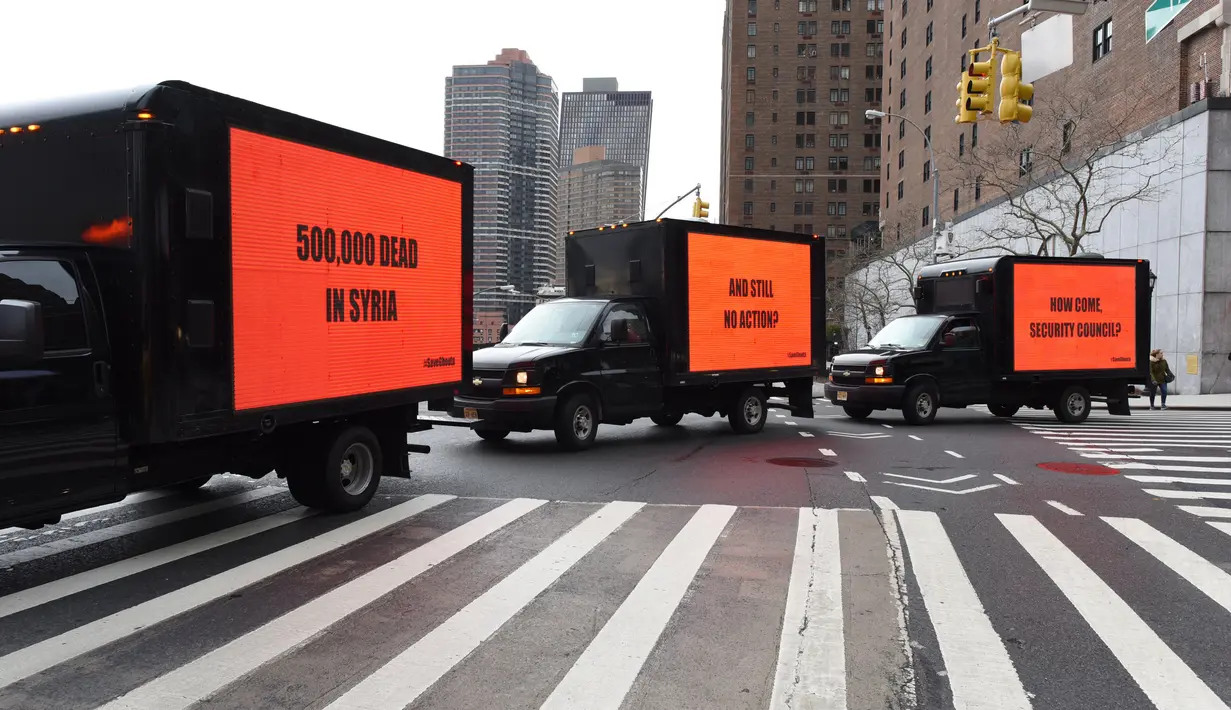 Tiga mobil box yang membawa billboard yang bertema kepedulian untuk Suriah turun ke jalan mengelilingi gedung Perserikatan Bangsa-Bangsa (PBB) di New York (22/2). (AFP Photo/Timothy A. Clary)