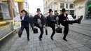 Sejumlah pria mengenakan kostum berjalan dengan mengangkat tinggi kakinya di Brno, Republik Ceko (7/1). Acara International Silly Walk Day ini digelar setiap tahun dan jatuh pada tanggal 7 Januari. (AFP Photo/Radek Mica)