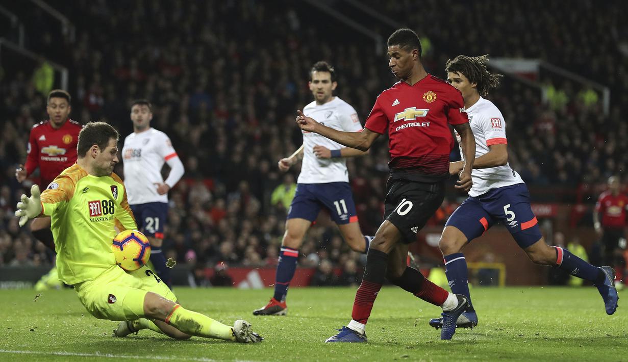 Kiper Bournemouth, Asmir Begovic, menghalau tendangan striker Manchester United, Marcus Rashford, pada laga Premier League di Stadion Old Trafford, Manchester, Minggu (30/12). MU menang 4-1 atas Bournemouth. (AP/Martin Rickett)