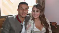 Gelandang Bayern Munchen, Thiago Alcantara dan istrinya Julia Vigas berpose saat menghadiri festival bir Oktoberfest 2017 di Munich, Jerman (23/9). (AFP Photo/Pool/Alexandra Beier)