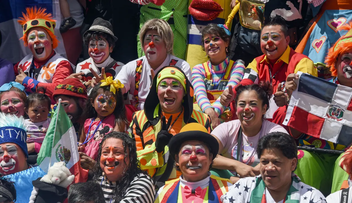 Para badut berfoto bersama selama parade pada Konvensi Badut Regional ke-5 di kota Guatemala, Rabu (19/9). Dalam acara tersebut, dengan kostum warna-warninya mereka berparade menelusuri jalanan pusat sejarah Guatemala City. (AFP / Johan ORDONEZ)