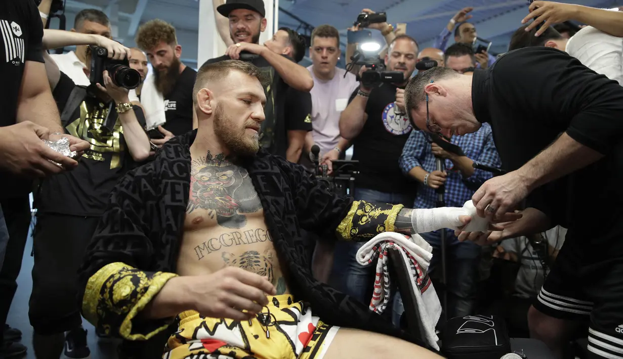 Petarung MMA, Conor McGregor, membalut tangannya dengan kain sebelum latihan terbuka di hadapan media di Las Vegas, Jumat (11/8/2017). McGregor akan bertanding melawan petinju Floyd Mayweather Jr pada  26 Agustus mendatang. (AP/John Locher)