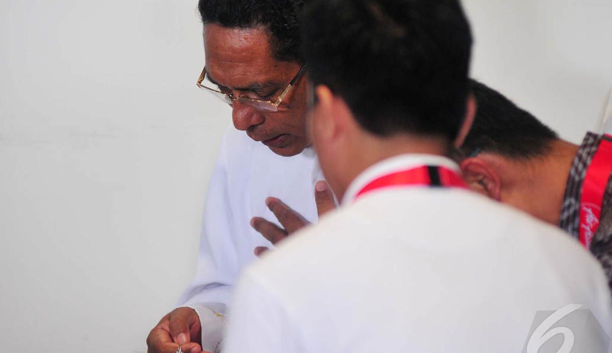 Seorang pemuka agama terlihat memimpin doa bersama keluarga penumpang AirAsia QZ8501, Surabaya, Selasa (30/12/2014). (Liputan6.com/Johan Tallo) 