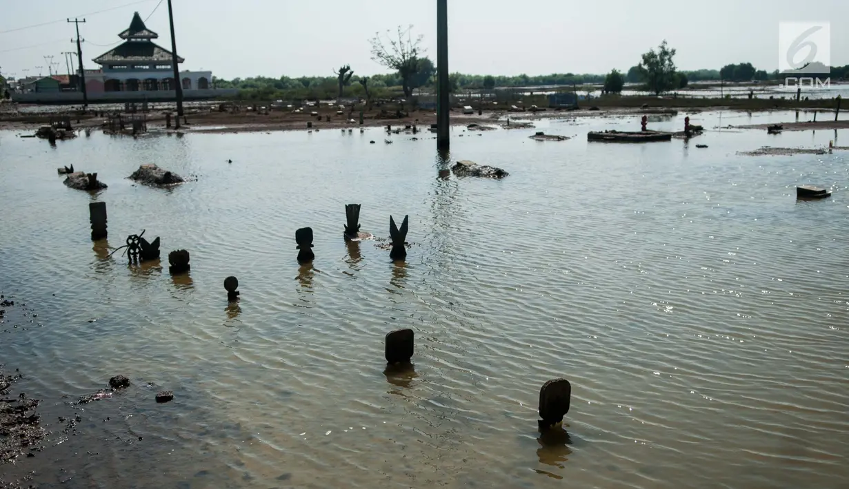 Banjir akibat pasang air laut di Desa Pantai Bahagia mengakibatkan pemakaman dan sekolah terendam serta akses jalan terputus, Jawa Barat, Jumat (9/6).(Liputan6.com/Gempur M Surya)