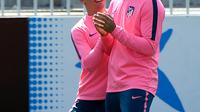 Penyerang Atletico Madrid, Antoine Griezmann dan Diego Costa bercanda saat sesi latihan di Ciudad Deportiva Wanda di Madrid (2/5). Pada leg pertama Atletico Madrid bermain imbang 1-1 atas Arsenal di Emirates Stadium. (AFP Photo/Pierre-Philippe Marcou)