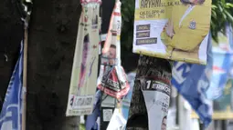 Sejumlah alat peraga kampanye (APK) calon anggota legislatif (caleg) memenuhi pepohonan yang berada di pinggir jalan, Jakarta, Rabu (20/3). Pemasangan APK tersebut melanggar aturan PKPU Nomor 23 Pasal 31 Tentang Bahan Kampanye. (merdeka.com/Iqbal Nugroho)