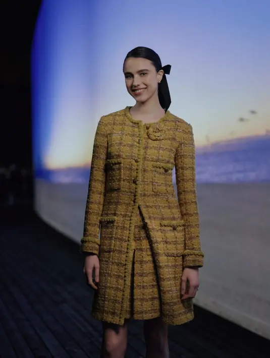 Margaret QUALLEY, CHANEL Ambassador, mengenakan coat tweed berwarna kuning, dengan rok kulot senada, look 12, dari koleksi CHANEL Métiers d’Art 2023/24. Aksesoris, tas dan sepatu CHANEL.  [Foto: Chanel.dok]