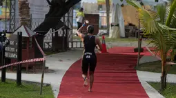 Peserta menyiram air saat berlari selama Rhino Cross Triathlon 2018 di Kawasan Tanjung Lesung, Pandeglang, Banten, Minggu (30/9). Rhino Cross Triathlon diikuti lebih dari 200 peserta dari dalam negeri dan manca negara. (Liputan6.com/HO/Nick Hanoatubun)