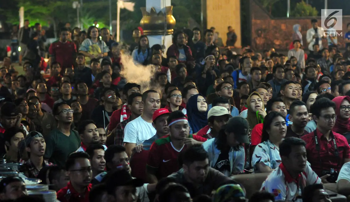 Sejumlah warga menonton pertandingan sepak bola Indonesia vs Malaysia di pertandingan Sea Games 2017 di Area Kementerian Pemuda dan Olahraga, Jakarta, Sabtu (27/8). Pada pertandingan tersebut Indonesia kalah 1-0 dari Malaysia. (Liputan6.com/Helmi Afandi)