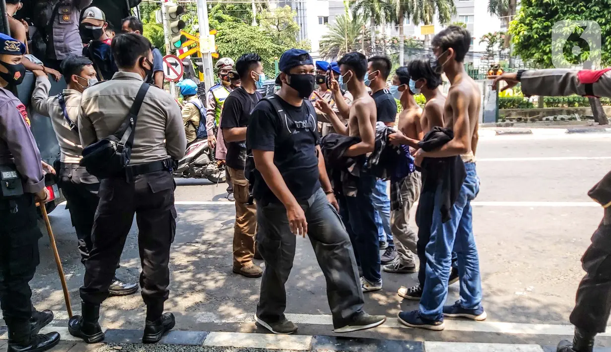 Sejumlah remaja diamankan aparat kepolisian saat berkumpul di Kawasan Palmerah, Jakarta, Kamis (8/10/2020). Dari hasil pemeriksaan, mereka turun ke jalan karena mendapatkan undangan dari media sosial untuk melaksanakan aksi unjuk rasa di sekitar DPR. (Liputan6.com/Faizal Fanani)