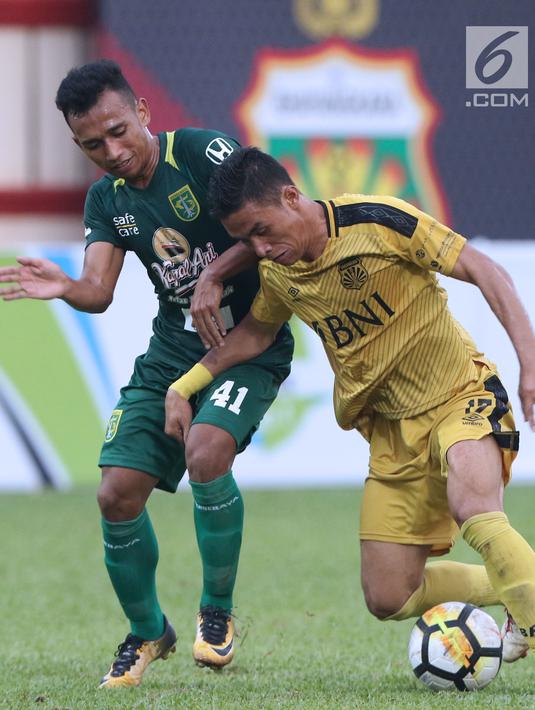 Pemain Bhayangkara FC, Alsan Sanda (kiri) berebut dengan pemain Persebaya, Irfan Jaya pada lanjutan Go-Jek Liga 1 Indonesia bersama Bukalapak di Lapangan PTIK, Jakarta, Rabu (11/7). Laga berakhir imbang. (Liputan6.com/Helmi Fthriansyah)