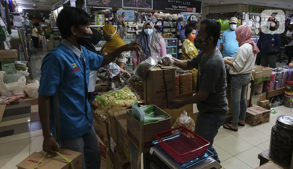 Pedagang kue kering melayani pembeli di Pasar Mayestik, Jakarta, Senin (3/5/2021). Omzet penjualan kue kering menjelang Lebaran tahun ini mengalami peningkatan hingga 70 persen dari tahun sebelumnya yang mengalami penurunan hingga 70 persen. (Liputan6.com/Johan Tallo)
